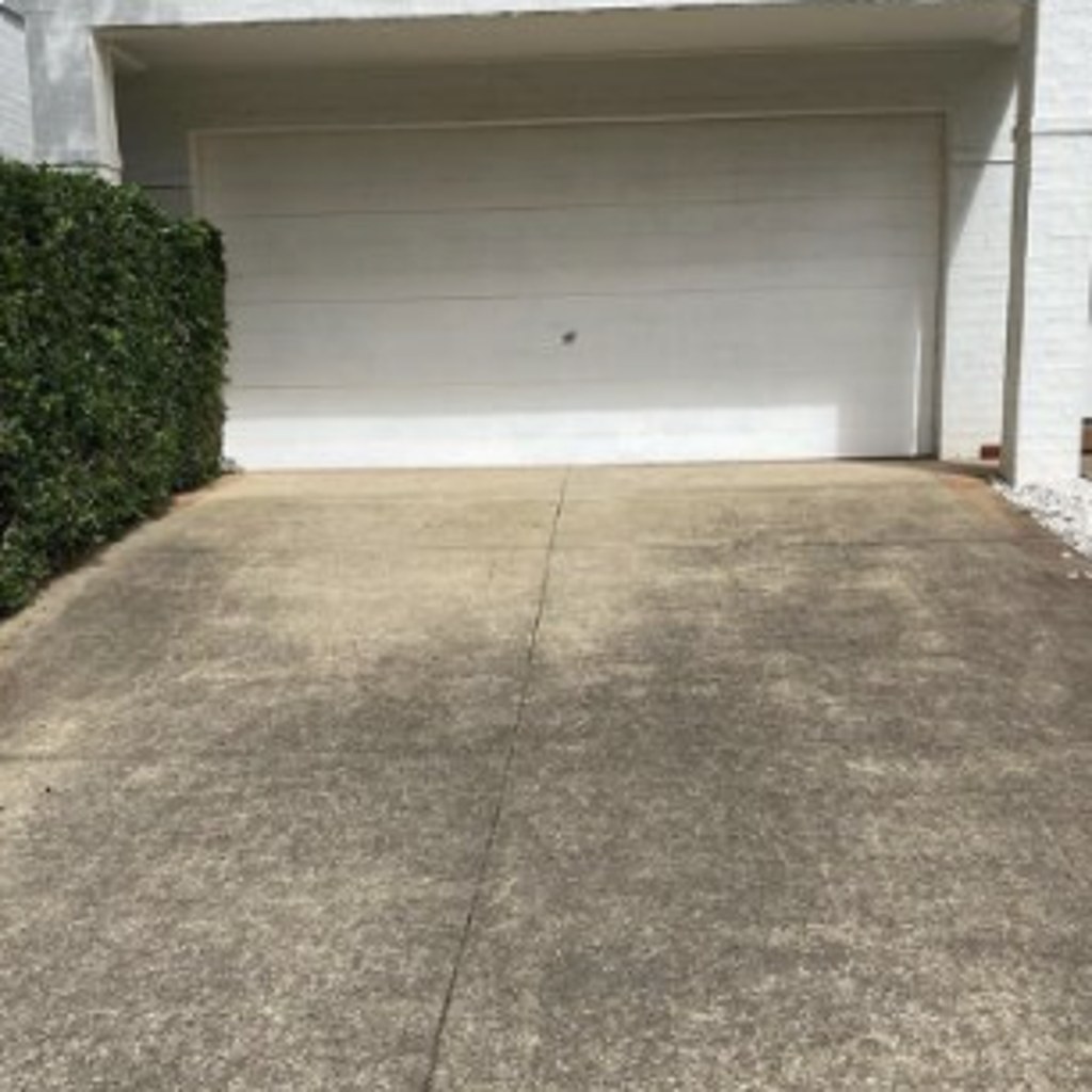Grey, stained concrete driveway before surface cleaning